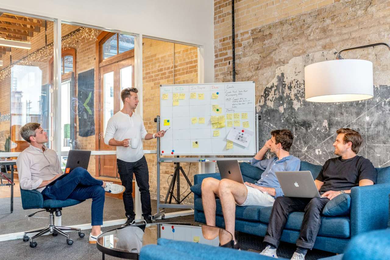 Small team planning a website project around a whiteboard in a bright office