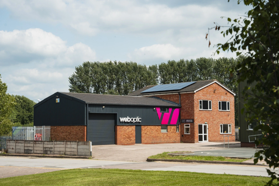 Web Optic's Hixon studio with company signage and rooftop solar panels
